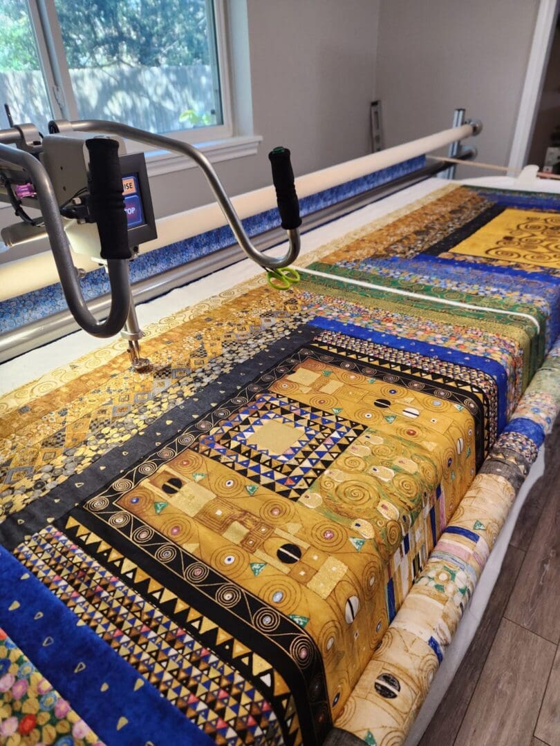 A colorful quilt with intricate patterns on a quilting machine.
