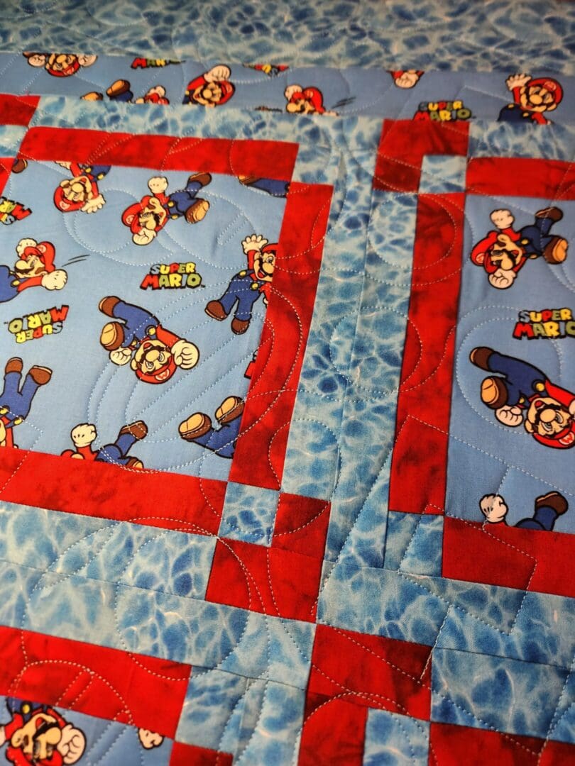 Fabric with Mario and Luigi cartoon characters in a quilt pattern.