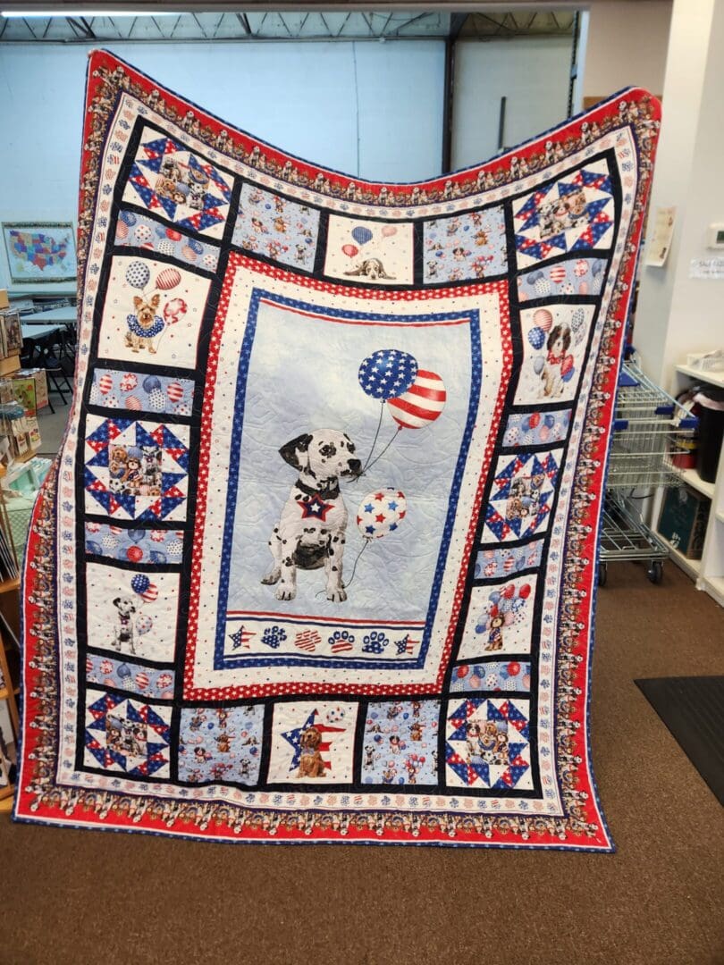 A colorful quilt featuring a central dog and patriotic designs.