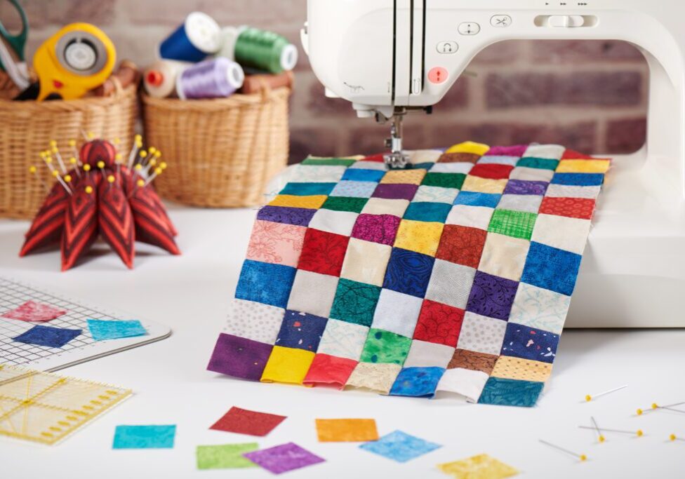 Sewing machine with colorful patchwork quilt.